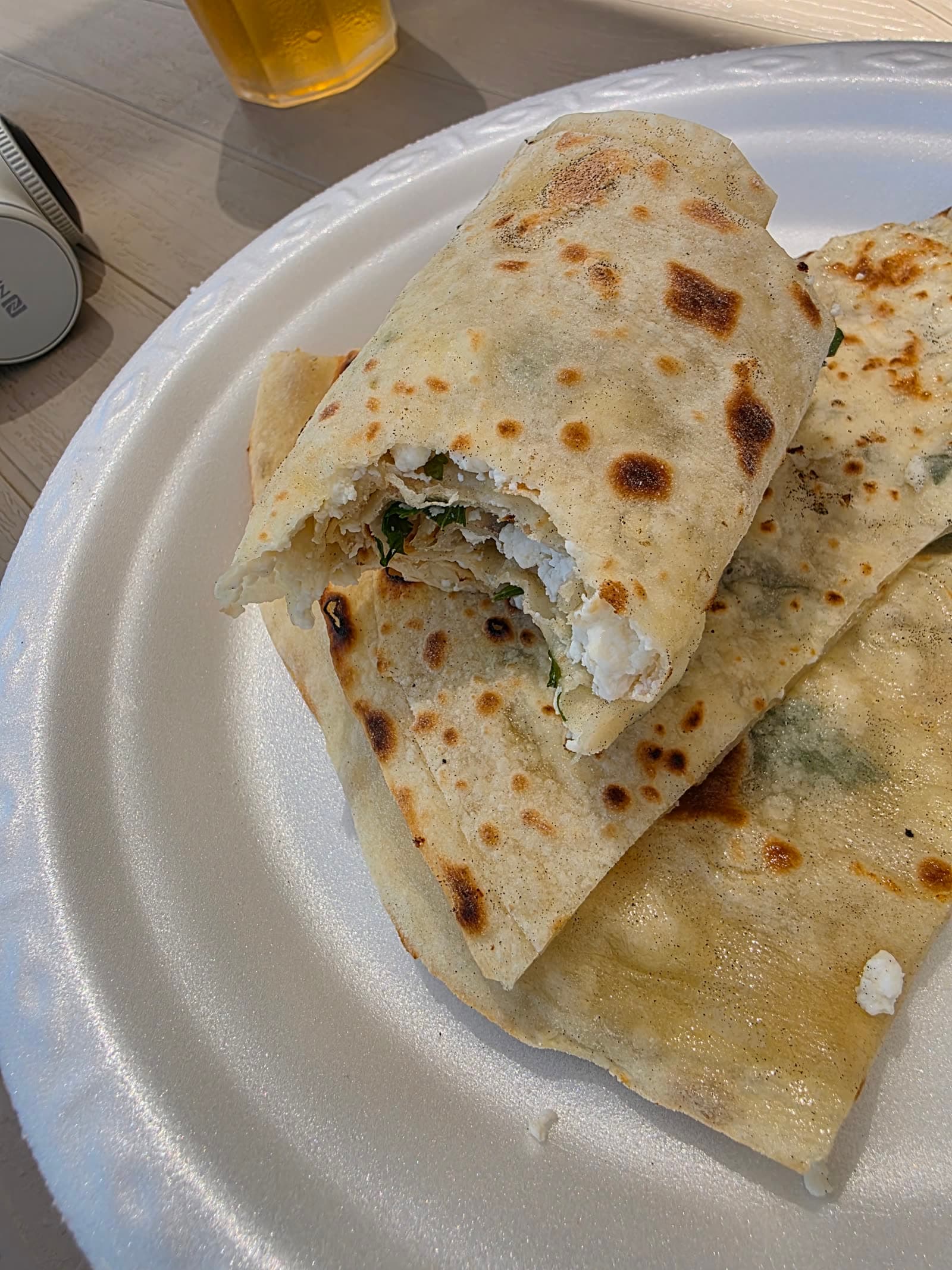 Farfurie cu gözleme — lipie turcească subțire, umplută cu brânză și verdeață — și un pahar de bere alături.