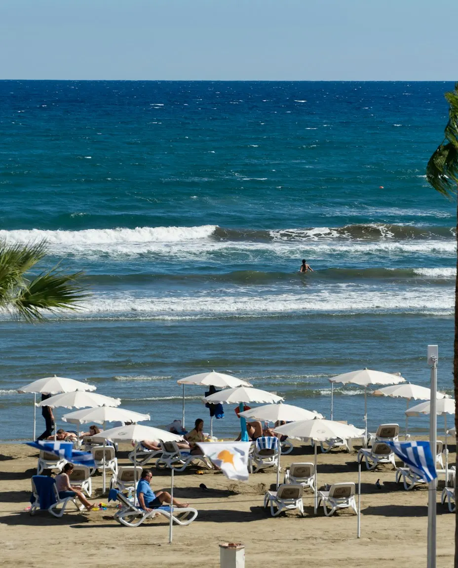 Umbrele albe și șezlonguri pe plaja din Larnaca