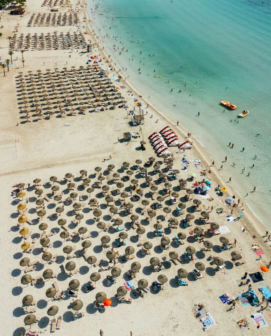 Plaja din Alcúdia, cu umbrele și nisip, într-o zi de vară
